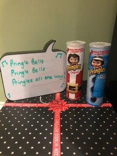 a table topped with two wrapped gifts and a sign that says, i pringle belie pringle pringles all the way