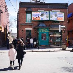 two women walking down the street in front of a building