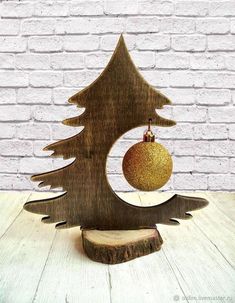 a wooden christmas tree with an ornament hanging from it