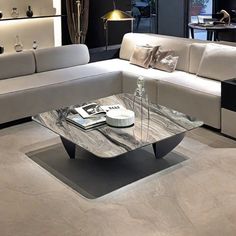 a modern living room with white couches and marble coffee table