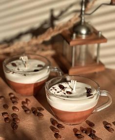 two cups filled with hot chocolate and whipped cream