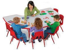 a group of children sitting at a table playing with letters and numbers on the table