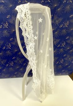 a piece of white lace sitting on top of a table next to a blue wall