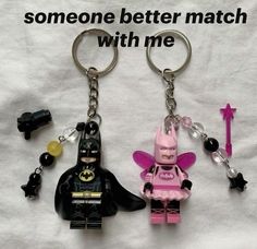 two lego batman keychains one is pink and the other is black with a batgirl on it