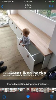 a small child is standing in an open drawer on the floor next to a window