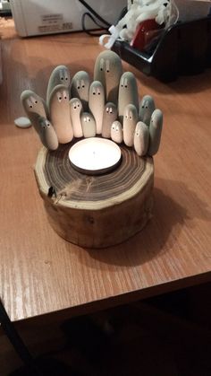 a group of ghost figurines sitting on top of a wooden table next to a white candle