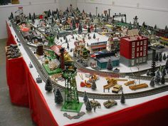 a large model train set on display in a room with red tablecloth and white walls