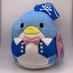 a stuffed toy penguin with a bow tie and pirate hat on it's head