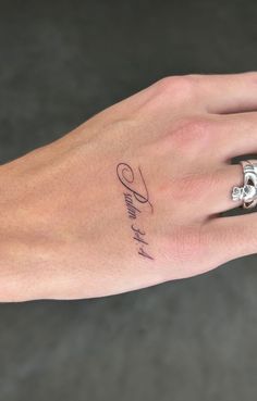 a woman's hand with a small tattoo on her left wrist and the word love written in cursive writing