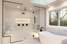 a bathroom with a large white bathtub next to a walk in shower