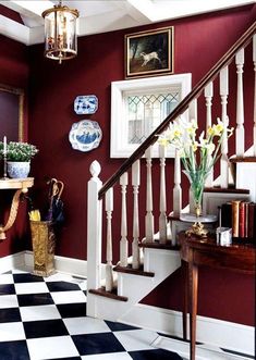 a room with red walls and white railings, black and white checkered floor