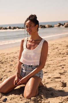 Solid crepe and crochet lace tank top. Scoop neckline. Crochet lace bodice. Sleeveless. Low scoop back with tasseled lace-up closure. Ruffle hem. Cropped length. Relaxed fit. 100% Rayon. Imported. Designed in LA. Model wears size S. Sleeveless Lace Crop Top For Beach, Sleeveless Crochet Lace Top For Beach Season, Summer Tank Top With Lace Trim And Scoop Neck, Sleeveless Lace Top For Summer Beach, Summer Cropped Lace Tank Top, Sleeveless Crochet Trim Tank Top For Beach, Beach Crochet Tank Top, Sleeveless Crochet Lace Crop Top For Vacation, White Crochet Lace Sleeveless Crop Top