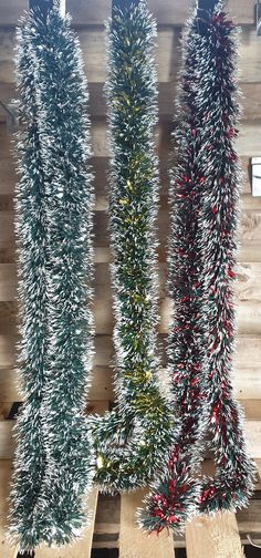 three christmas trees are lined up on wooden boards