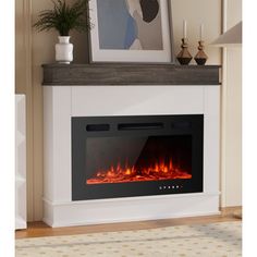 a white fireplace with an electric fire in the center and a framed photograph on top