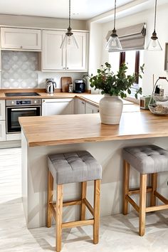 a kitchen with two stools and a center island