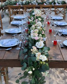 a long table with flowers and candles on it is set up for an outdoor dinner