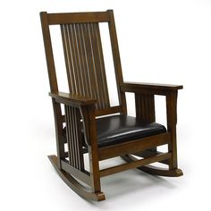 a wooden rocking chair with black leather seat and armrests on a white background