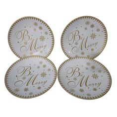 three white plates with gold lettering and snowflakes