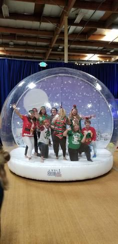 a group of people standing in front of a snow globe