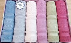 six different colored towels in a pink box