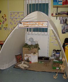 a room with a white tent on the floor and various items around it in front of a door