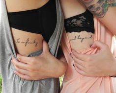 two women with tattoos on their stomachs are holding each other's hands and posing for the camera