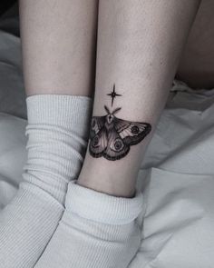 a woman's leg with a small butterfly tattoo on her left ankle and the star above it