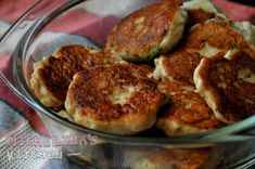 a glass bowl filled with fried food on top of a checkered table cloth,