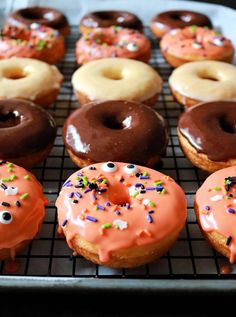 there are many doughnuts on the cooling rack and one has sprinkles