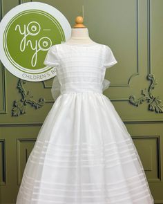 Andrea is a gorgeous and traditional first communion dress, it has pleats throughout the dress with a classical neckline. It is made with an optic white organza, it is very lightweight and ideal for humid weather. It has buttons on the back and strings to form a bow. Made in Spain Does not include crinoline Dry Clean 100% polyester Final sale, no exchanges nor returns will be accepted after purchase White First Communion Dress With Pleated Bodice, White Pleated Bodice Dress For First Communion, Classic Dresses With Fitted Bodice For First Communion, White Classic Dress For First Communion, White Fitted Bodice First Communion Dress With Short Sleeves, Classic White First Communion Dress, White Classic Dresses For Church, Classic White Dresses For Church, First Communion Dress