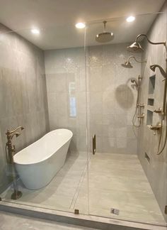 a white bath tub sitting inside of a bathroom next to a walk - in shower