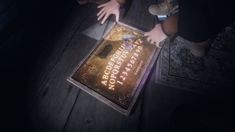 a person reaching for a book on a table in the dark with their hands over it