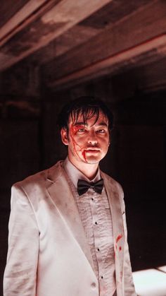 a man in a white suit with blood on his face