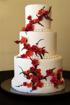 a three tiered cake with red flowers on it