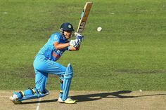 a cricket player hitting the ball with his bat