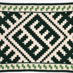 a green and white crocheted pillow on a white surface