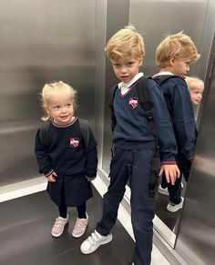 two young children standing in front of a mirror with their backs turned to the camera