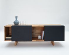 a black and wood entertainment center with two vases on the top, next to it