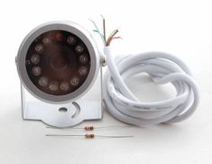 an image of a security camera with wires and plugs attached to it on a white surface