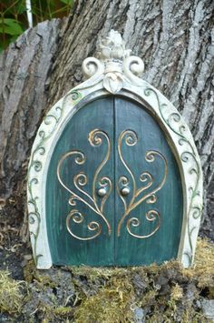 a green and white door sitting next to a tree