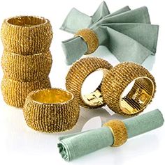 several different types of napkins and rings on a white surface with one rolled up in the shape of a bow