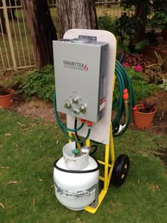 a water heater sitting in the grass next to a tree