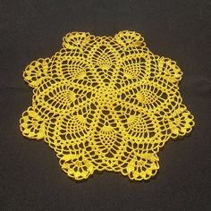 yellow crocheted doily on black background