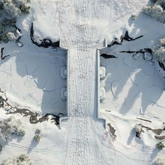 an aerial view of snow covered ground and trees