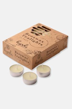 three tealight candles in a cardboard box