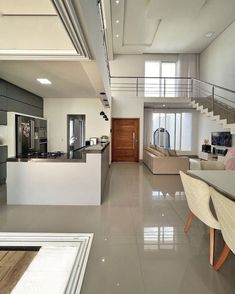 a kitchen and living room are shown in this modern style home, with stairs leading up to the second floor