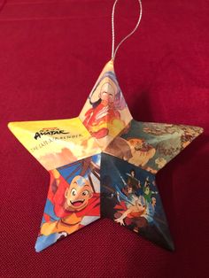 an ornament shaped like a star with cartoon characters hanging from it's sides