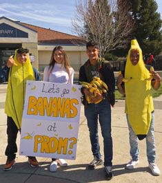 three people in banana costumes holding a sign