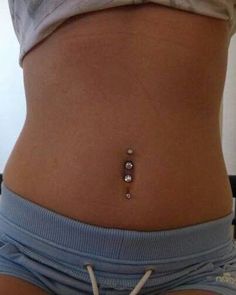 a woman's stomach with a tiny bead in the middle and small beads at the bottom