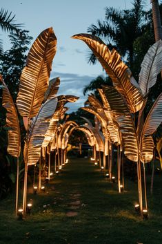 lighted palm trees are lined up on the grass